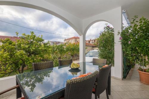 een eettafel buiten met stoelen en een glazen tafel bij Apartment Vinka in Trogir