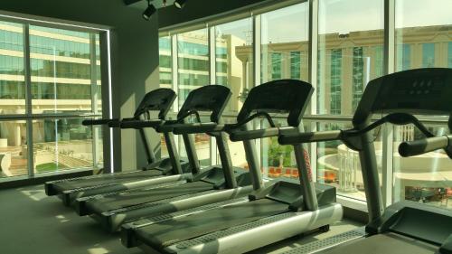 a row of treadmills in a gym with windows at Millennium Airport Hotel Dubai in Dubai
