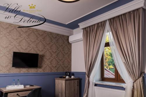 a room with blue walls and a window at Dwór Prezydencki Boutique Hotel & SPA in Tarnów