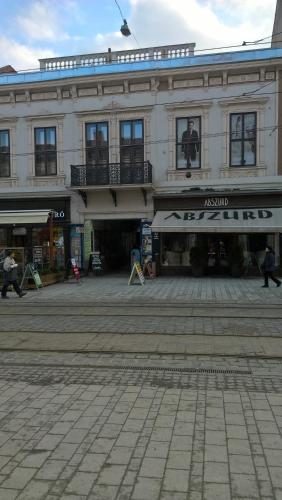 a building on a street with people walking in front of it at Széchenyi Apartman Miskolc belvárosban in Miskolc