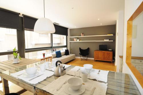 une salle à manger avec une table et un salon dans l'établissement RentBCN Gracia Deluxe, à Barcelone