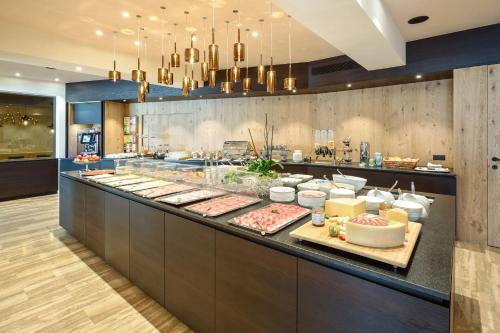 a buffet line in a restaurant with food on display at Granpanorama Hotel StephansHof in Villandro