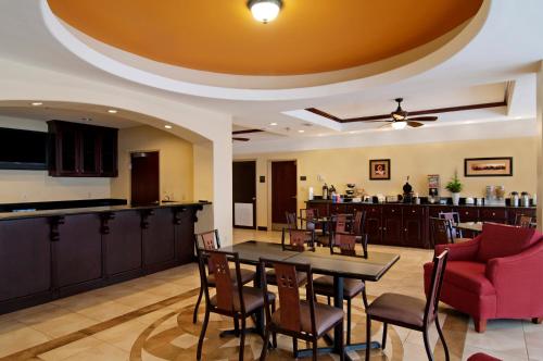a restaurant with a table and chairs and a bar at Super 8 by Wyndham Hidalgo at La Plaza Mall & Mcallen Airport in Hidalgo