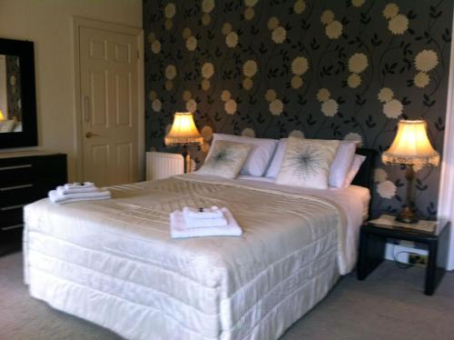 een slaapkamer met een groot wit bed met 2 lampen bij Carlingford House Town House Accommodation A91 TY06 in Carlingford