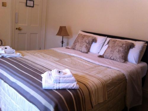 カーリングフォードにあるCarlingford House Town House Accommodation A91 TY06のベッドルーム1室(大型ベッド1台、タオル付)