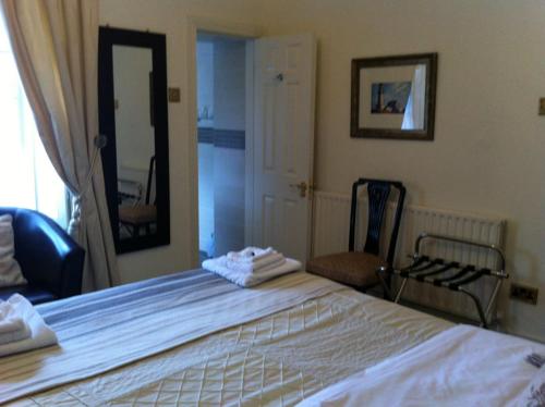 una camera da letto con un grande letto bianco e uno specchio di Carlingford House Town House Accommodation A91 TY06 a Carlingford