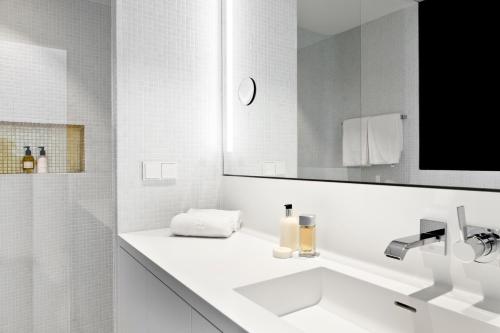 a white bathroom with a sink and a mirror at PhilsPlace Full-Service Apartments Vienna in Vienna