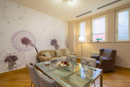 a living room with a table and a couch at Elegant Flat at Municipio by Napoliapartments in Naples
