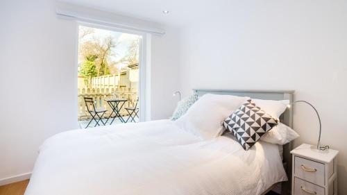 um quarto com uma cama branca e uma janela em The Wing -Near to the beaches and Bournemouth University em Bournemouth