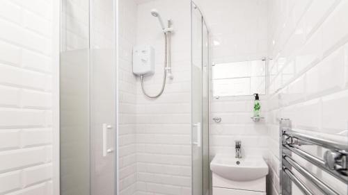 Un baño blanco con ducha y WC. en The Wing -Near to the beaches and Bournemouth University, en Bournemouth