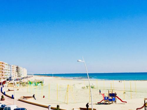 a beach with volley ball courts and the ocean at Brasilia Hôtel in Palavas-les-Flots
