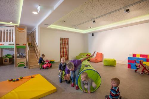 a group of children playing in a room with play equipment at Alpin Family Resort Seetal in Kaltenbach