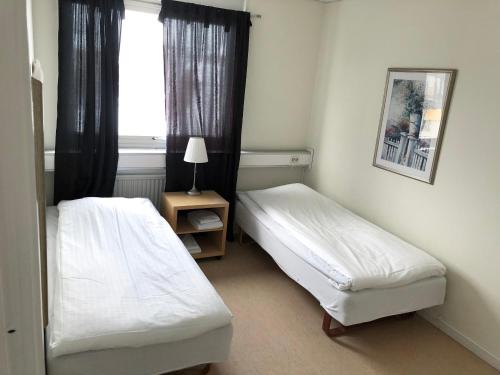 a hotel room with two beds and a window at Grand Hotell Bollnäs in Bollnäs