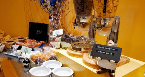 a table topped with bowls and plates on a table with food at Hotel Don Paco in Seville