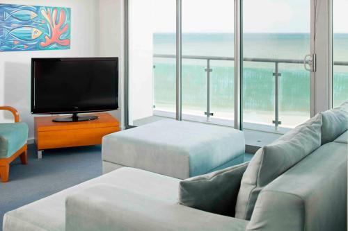 a living room filled with furniture and a tv at Seashells Mandurah in Mandurah