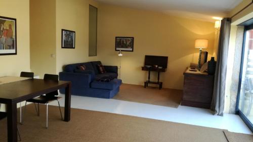 a living room with a blue couch and a table at Casa na Quinta de Valinhas in Vitorino dos Piães