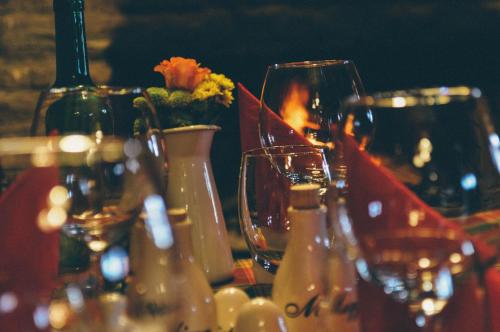 a table with wine glasses and flowers on it at Pyszna Stajenka in Bąków