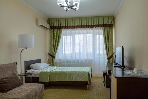 Habitación de hotel con cama y ventana en Yuzhnaya Hotel, en Pyatigorsk