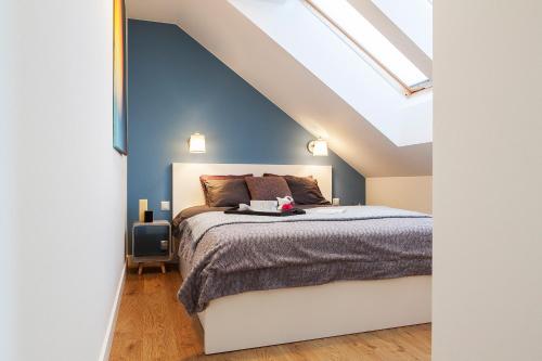- une chambre avec un lit et un mur bleu dans l'établissement ArtHouse Pelnik, à Łukta