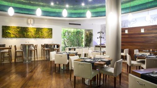 a dining room with tables and white chairs at Gran Hotel Albacete in Albacete
