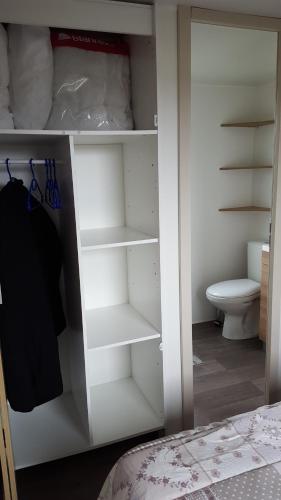 Cette chambre comprend un placard blanc et des toilettes. dans l'établissement Mobile Home 701, aux Mathes