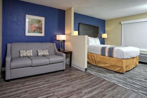 una camera d'albergo con letto e divano di Eagles Nest Inn a Statesboro