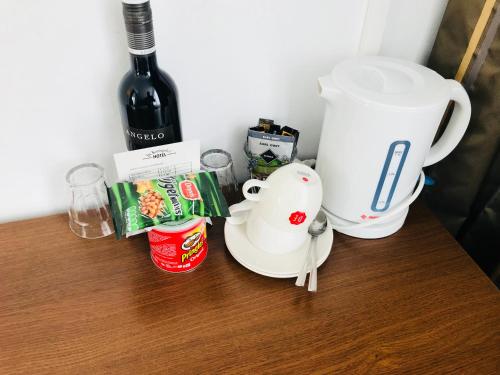 a table with a coffee maker and a bottle of wine at Hotel De Koningshof in Noordwijk aan Zee