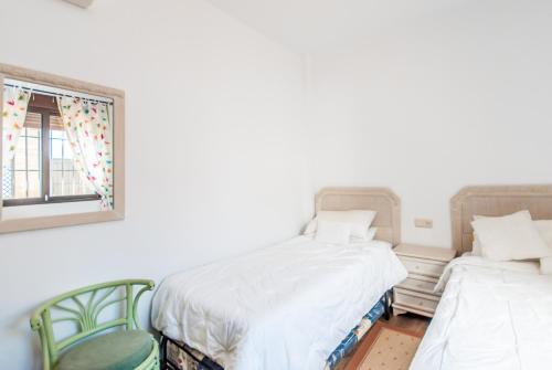 アラウリン・エル・グランデにあるCubo's Villa las Terrazasの窓と椅子2脚が備わる客室で、ベッド2台が備わります。