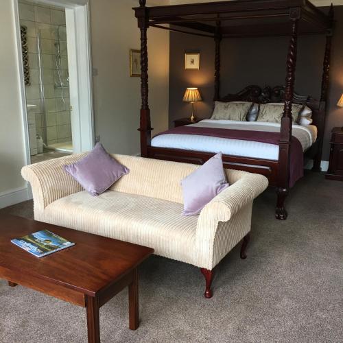 a bedroom with a bed and two chairs and a table at The Eagles Hotel in Llanrwst