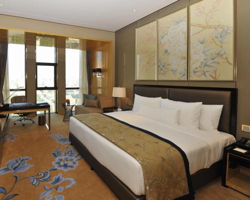a bedroom with a large bed and a piano at Wanda Vista Taiyuan in Taiyuan