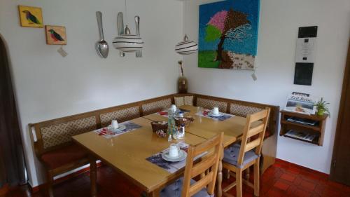 a dining room with a wooden table and chairs at Pension Bergblick in Ruhpolding