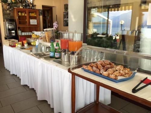 a buffet line with a tray of pastries and drinks at Hotel Lumin in Cremia