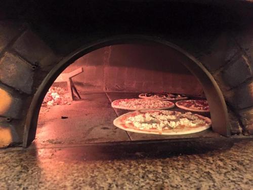 a group of pizzas in a brick oven at Hotel Lumin in Cremia
