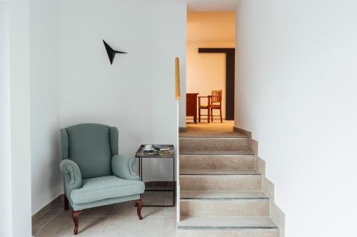 a stairway with a blue chair next to a stair case at Mirador Ardea Mendixur in Mendijur