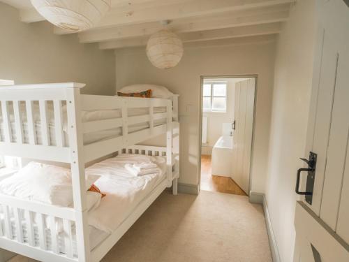 a bedroom with two bunk beds and a bathroom at Holly Farm in Doddington