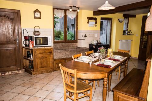 una cucina e una sala da pranzo con tavolo e sedie in legno di la grange aux hirondelles a Athienville