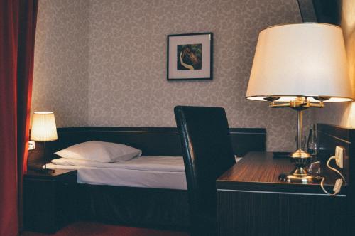 a bedroom with a bed and a desk with a lamp at Pyszna Stajenka in Bąków