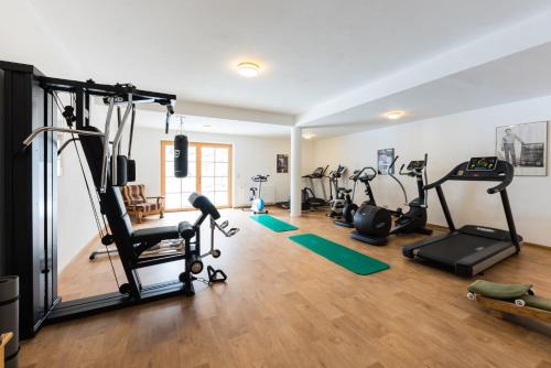 a gym with several treadmills and exercise bikes at Hotel Krimmlerfälle in Krimml