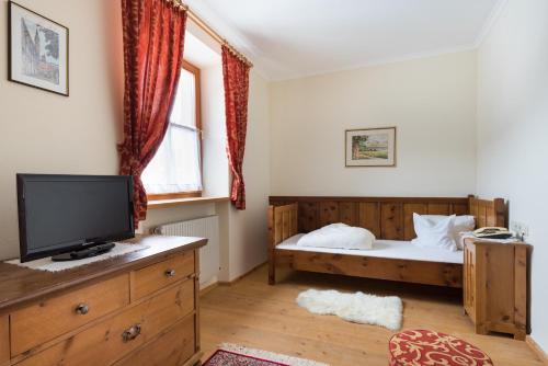 a bedroom with a bed and a flat screen tv at Hotel Krimmlerfälle in Krimml