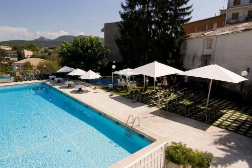 a swimming pool with umbrellas and tables and chairs at Hotel Segle XX in Tremp