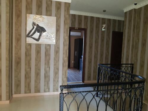 a hallway with a painting on a striped wall at Hotel New Telavi in Tʼelavi