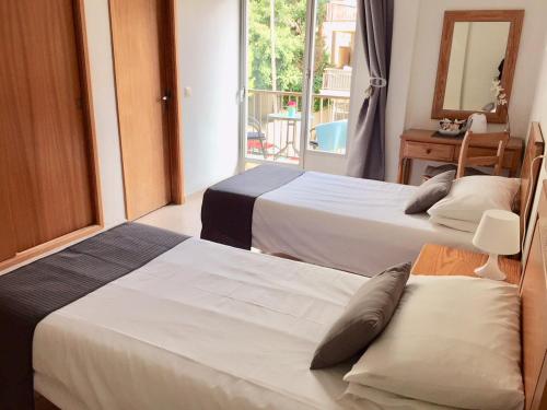 a hotel room with two beds and a balcony at Sol y Luna Cala Millor in Cala Millor