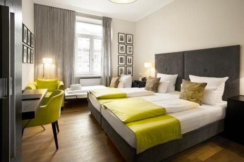 フランクフルト・アム・マインにあるホテル ハンバーガー ホーフのベッド2台とデスクが備わるホテルルームです。