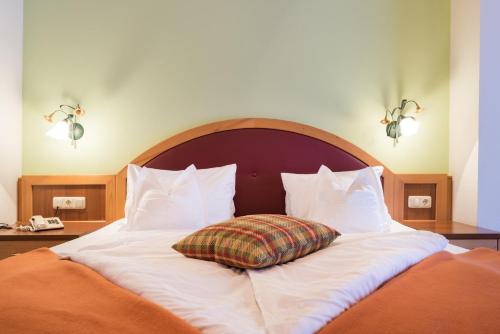 a bed with a pillow sitting on top of it at Hotel Krimmlerfälle in Krimml