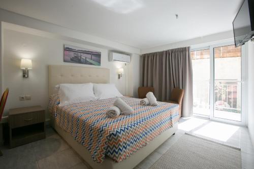 a bedroom with a bed with two pillows on it at City Life Port Hotel in Heraklio Town