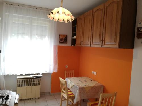 a kitchen with a table and a chandelier at Liszt Apartman in Szombathely
