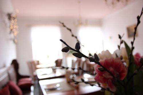 un comedor con una mesa con flores. en Hotel Klostergarten en Eisenach
