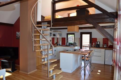 une cuisine avec un escalier en colimaçon menant à une mezzanine dans l'établissement Ferienhaus Jungk, à Eisenach