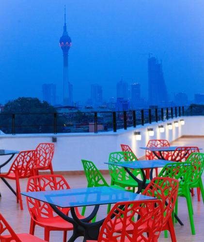 a group of tables and chairs with a view of a city at Golden Pier City Hotel in Colombo