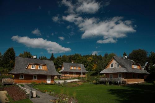 eine Gruppe von drei Häusern in einem Hof in der Unterkunft Richňava park in Štiavnické Bane